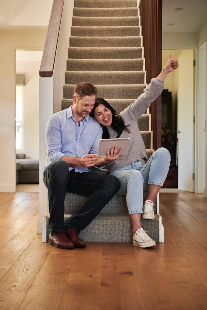 Man and woman sitting on steps celebrating closing a deal for real estate in Jamaica