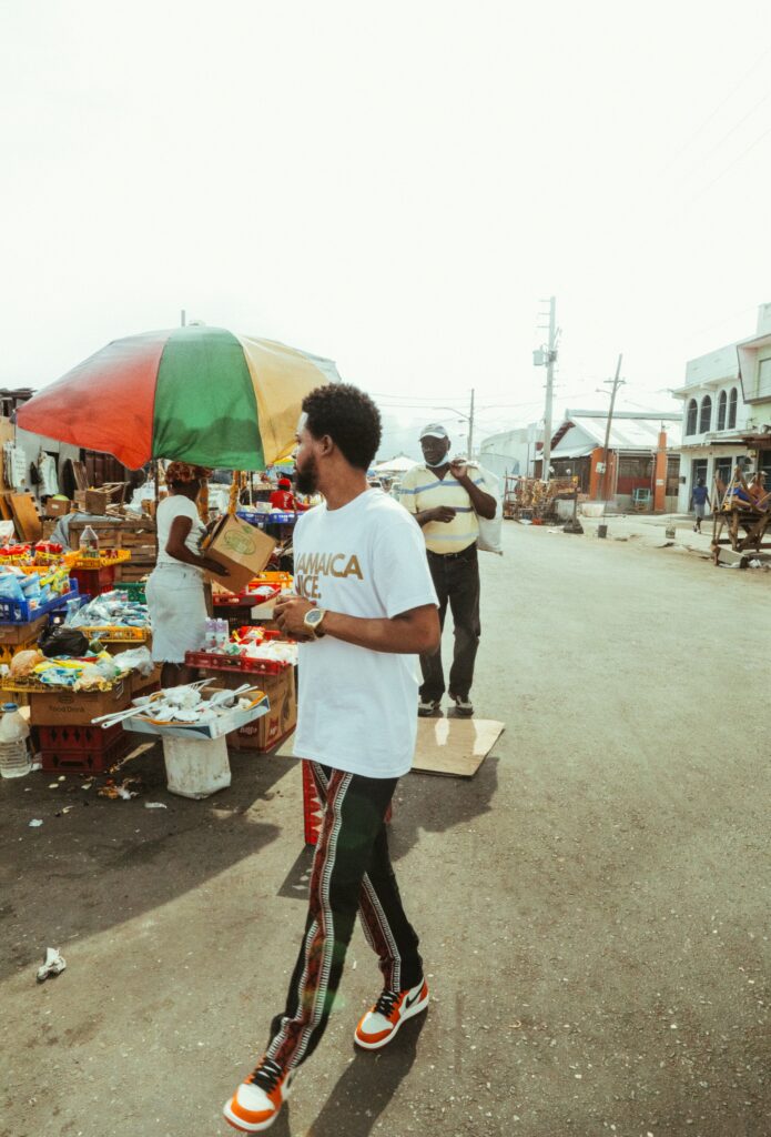 Man in Jamaica shirt walking in the market and looking for real estate in Jamaica to buy nearby