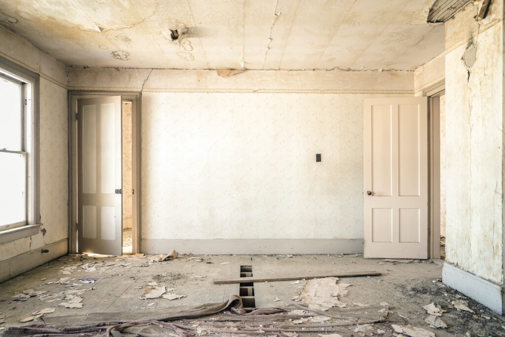 Room with stripping floors and walls ready to be renovated for real estate investment in Jamaica